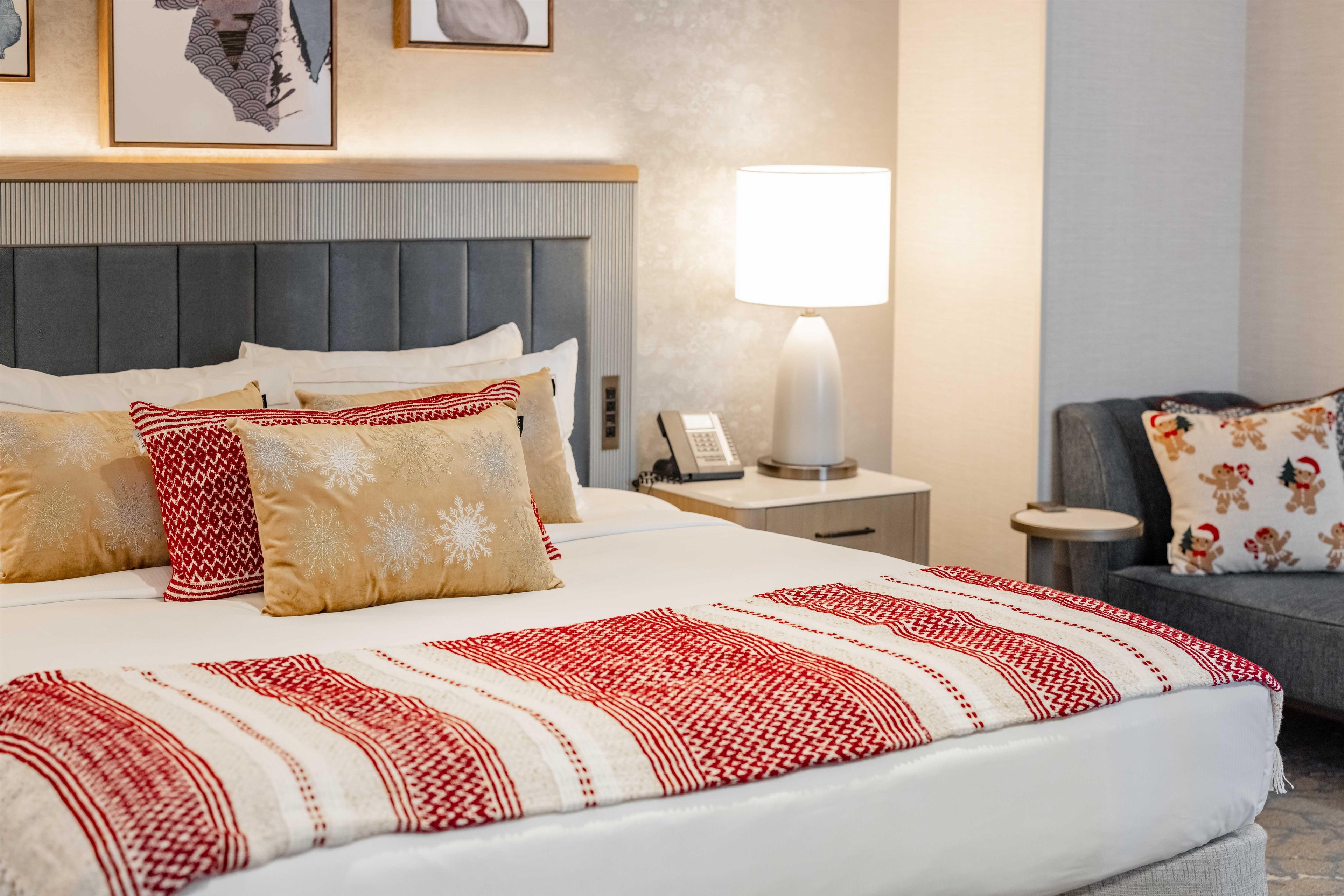 Ein Hotelzimmer mit einem großen Bett, einer Nachttischlampe, einem Beistelltisch und einem Sessel.