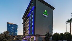 A Holiday Inn Express hotel with a modern design, featuring multiple floors and a prominent sign on the side.