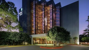A modern building with a glass facade, labeled "EMBA SUIT" on the side. - Embassy Suites by Hilton Atlanta Perimeter Center (Atlanta)