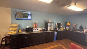 A kitchen area with a microwave, coffee machine, and a refrigerator. There is a map on the wall and a trash can near the counter. - Days Inn by Wyndham Salina I-70 (Salina)