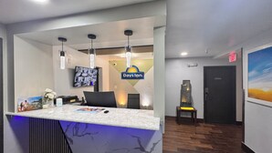 A reception area with a marble counter, a television mounted on the wall, and a sign for 'Days Inn'. - Days Inn by Wyndham Salina I-70 (Salina)