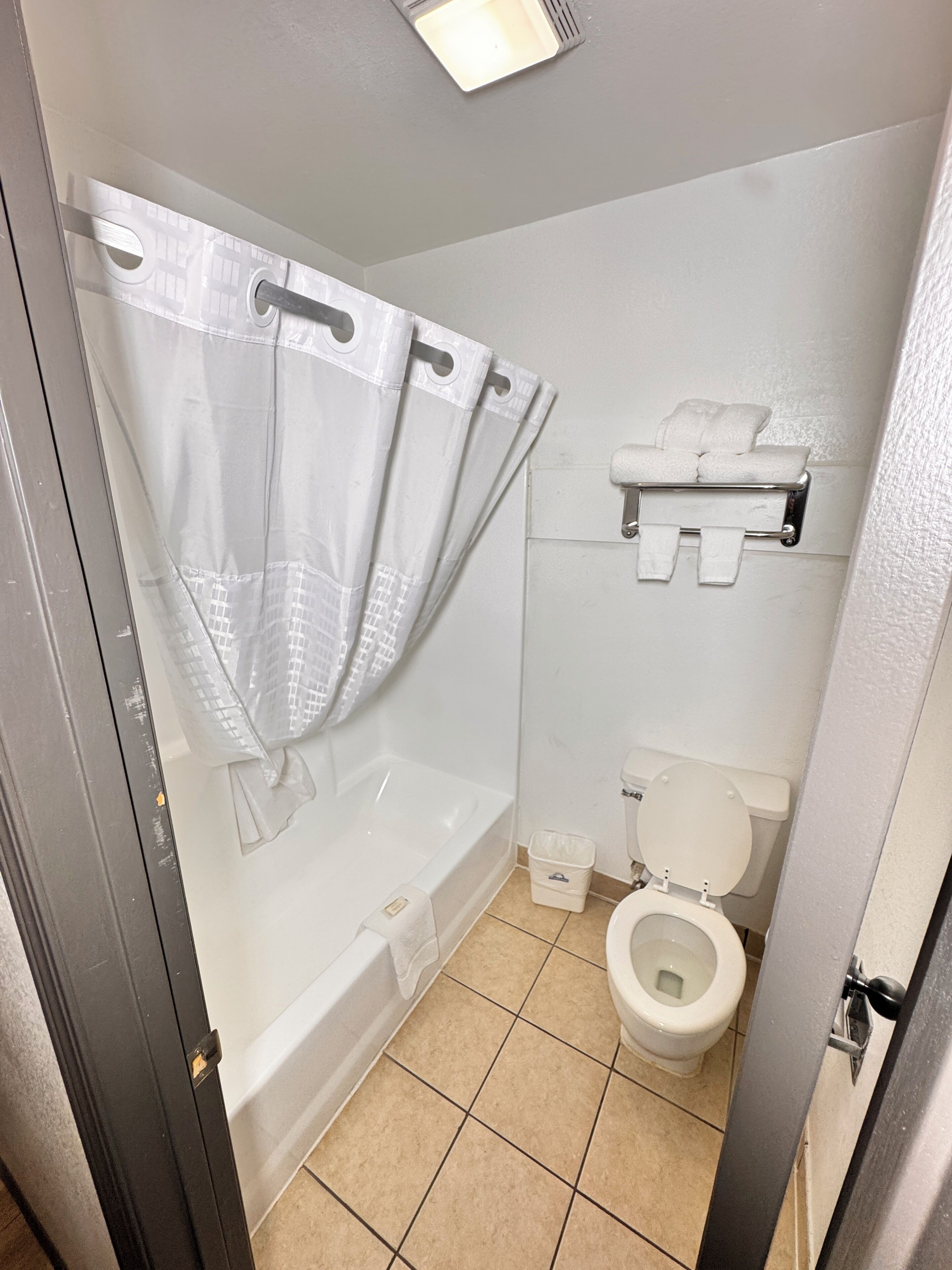Un bagno con vasca, servizi igienici e tenda da doccia.