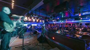 A live music performance area with a stage, seating, and a crowd.