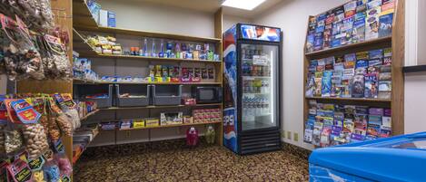 A convenience store with shelves stocked with snacks, beverages, and travel books.