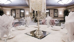A banquet hall with tables set for a formal event, featuring white floral centerpieces and elegant tableware. - Grand Vista Hotel (Simi Valley)