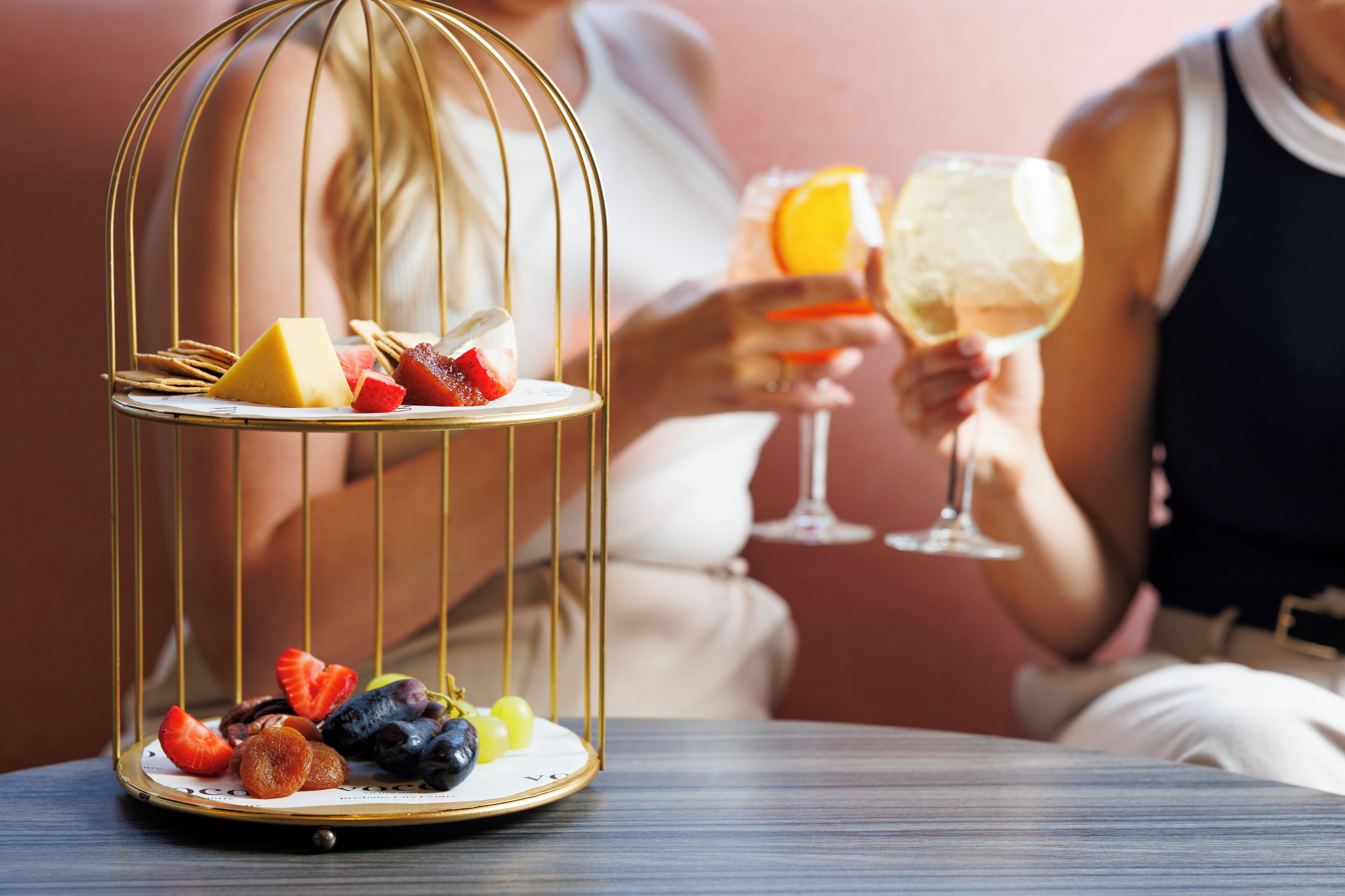 A dessert trolley with assorted fruits and a wine glass.