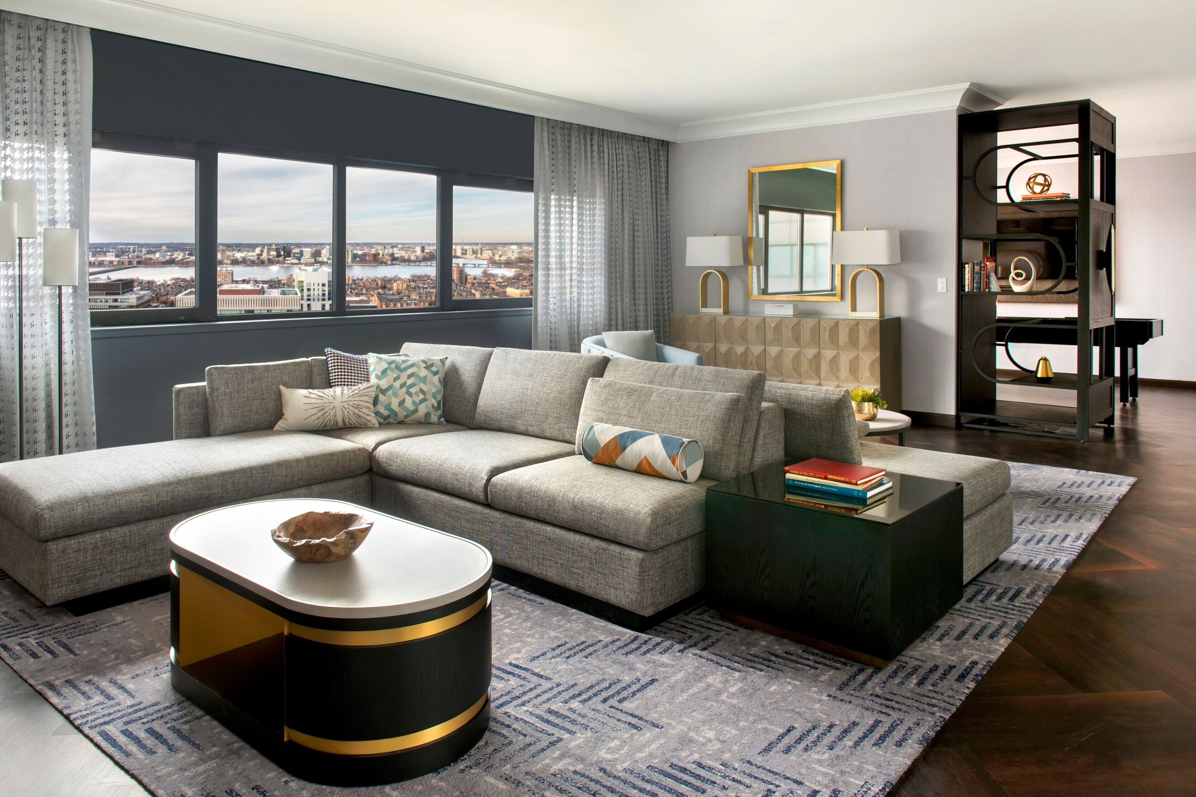 A modern living room with a sectional sofa, a round coffee table, and a bookshelf.