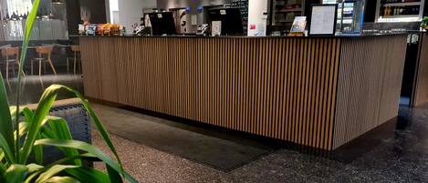 Una recepción de diseño moderno, con una pantalla digital y un tablero de menú.