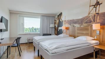 Habitación de hotel con dos camas, un escritorio, una silla, un televisor y un cuadro de un puente.