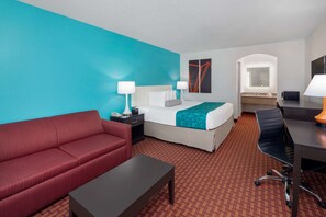 A hotel room with a bed, a red sofa, a desk, and a chair. - Howard Johnson by Wyndham Rock Hill (Rock Hill)