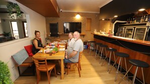 A modern kitchen with a dining area, wooden furniture, and a bar counter with stools. - Great Eastern Motor Inn (Monkland)