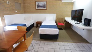 A hotel room with two beds, a TV, a desk, and a small table.
