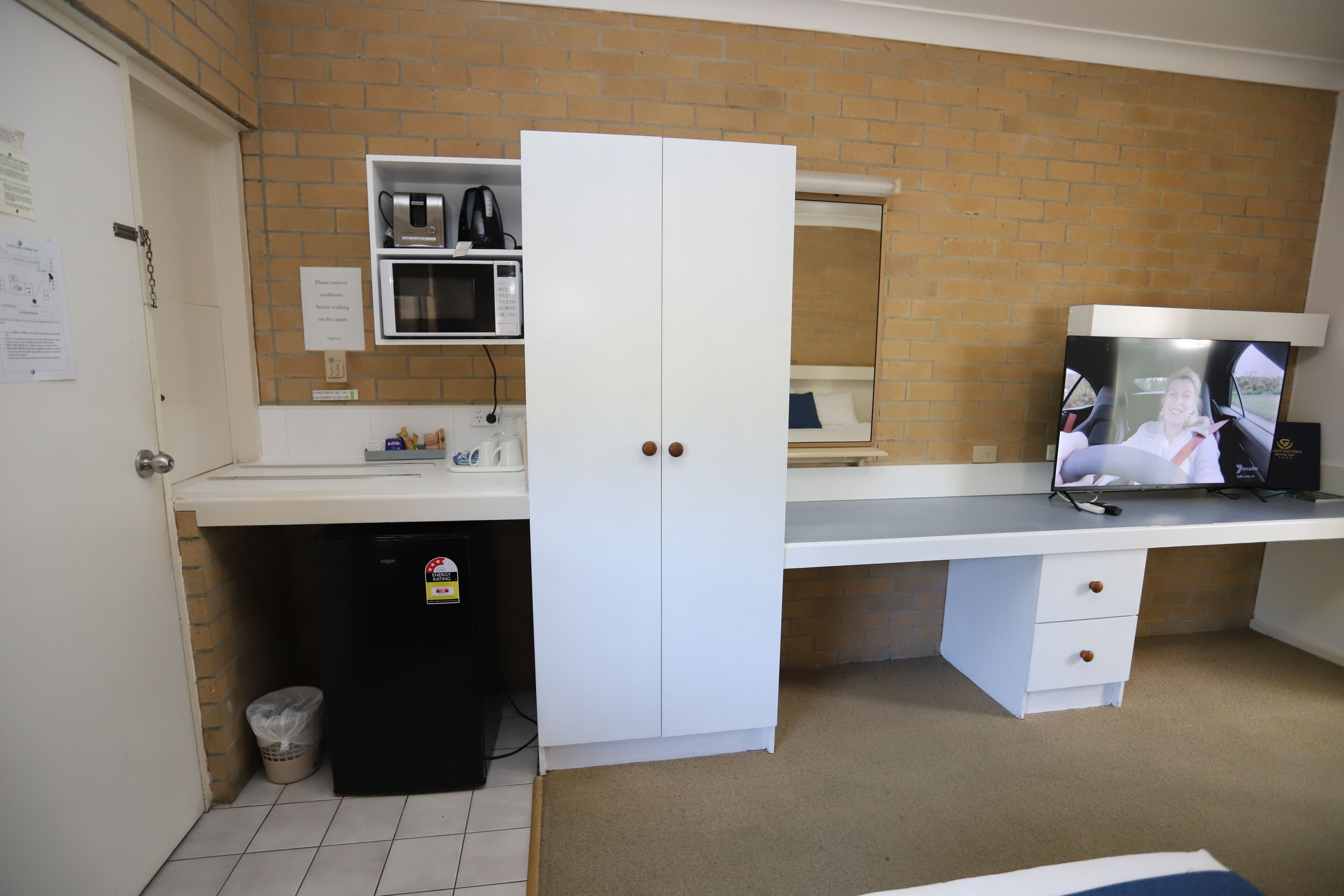 A compact kitchen with a microwave, a coffee maker, and a sink.