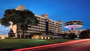 A Marriott hotel with a modern design, featuring a large building with a prominent 'Marriott' sign, a circular structure, and a well-maintained lawn. - Houston Airport Marriott at George Bush Intercontinental (Houston)