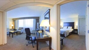 A hotel room with a desk, chair, bed, and a view of the outdoors. - Holiday Inn Birmingham-Airport by IHG (Birmingham)