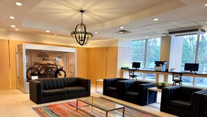 A modern lobby with a black sofa, armchairs, a coffee table, and a colorful striped rug. - Holiday Inn Birmingham-Airport by IHG (Birmingham)