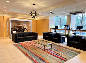 A modern lobby with a black sofa, armchairs, a coffee table, and a colorful striped rug. - Holiday Inn Birmingham-Airport by IHG (Birmingham)