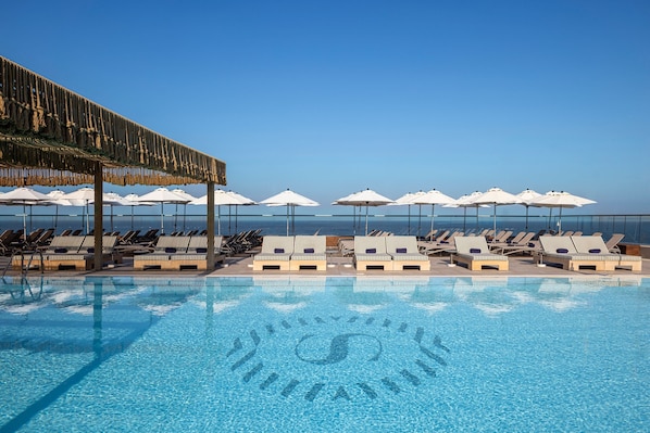 Piscine extérieure, parasols de plage, chaises longues