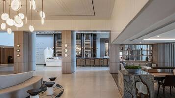 Un interior moderno con una barra central, asientos y una mesa de centro de mármol.
