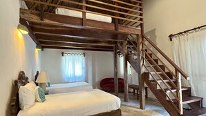 Un dormitorio con una cama nido de madera, una escalera y un ventilador de techo.