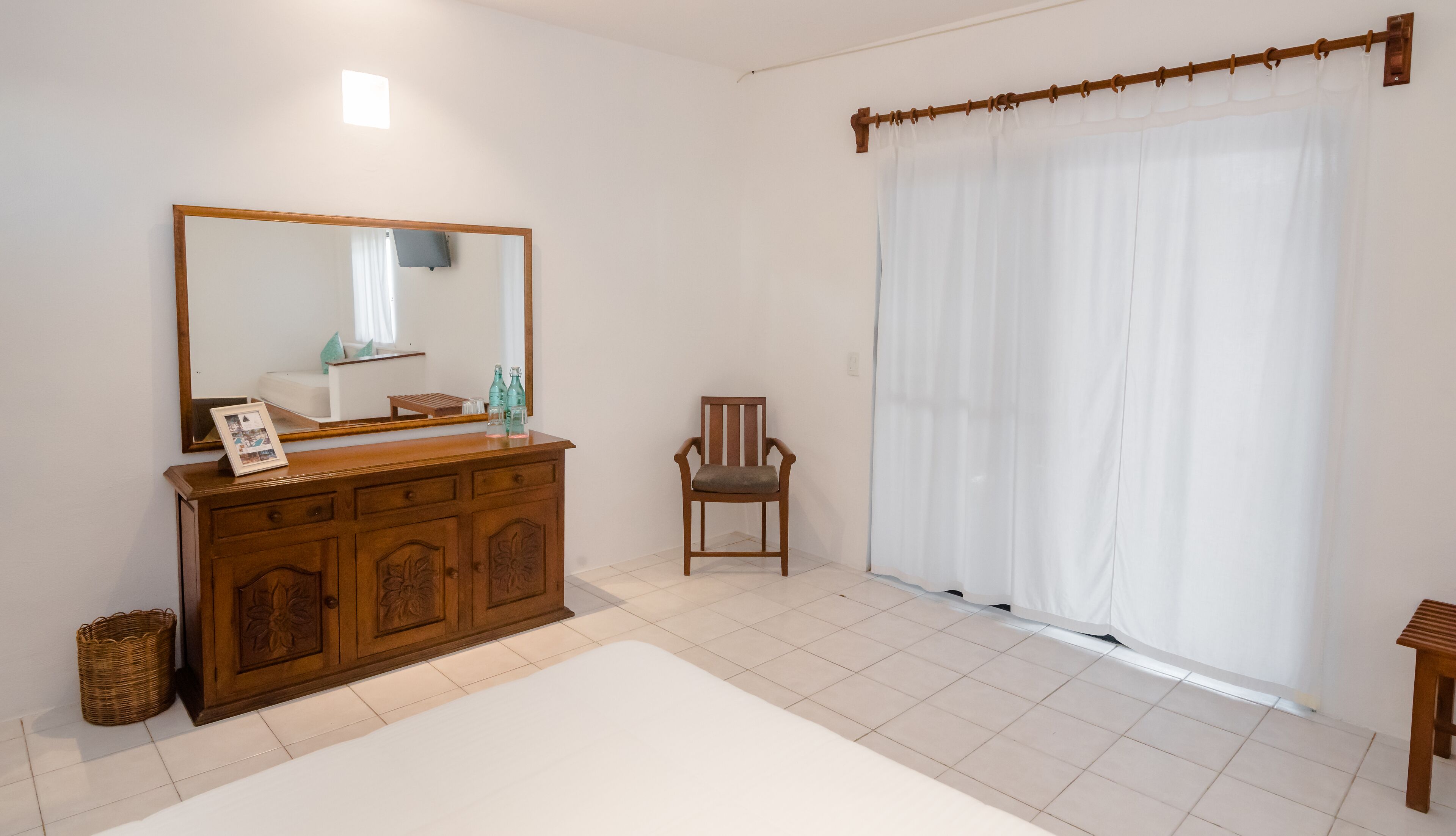 A clean, modern bathroom with a wooden vanity, a large mirror, and a white bathtub.