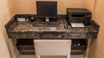 A desktop computer with a monitor, keyboard, and printer on a granite countertop.