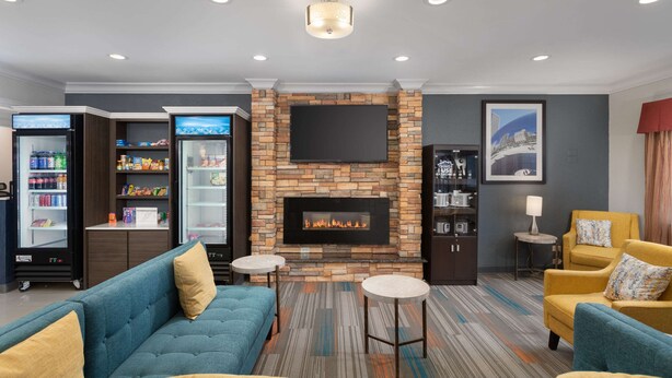 A modern living room with a fireplace, seating, and a television.