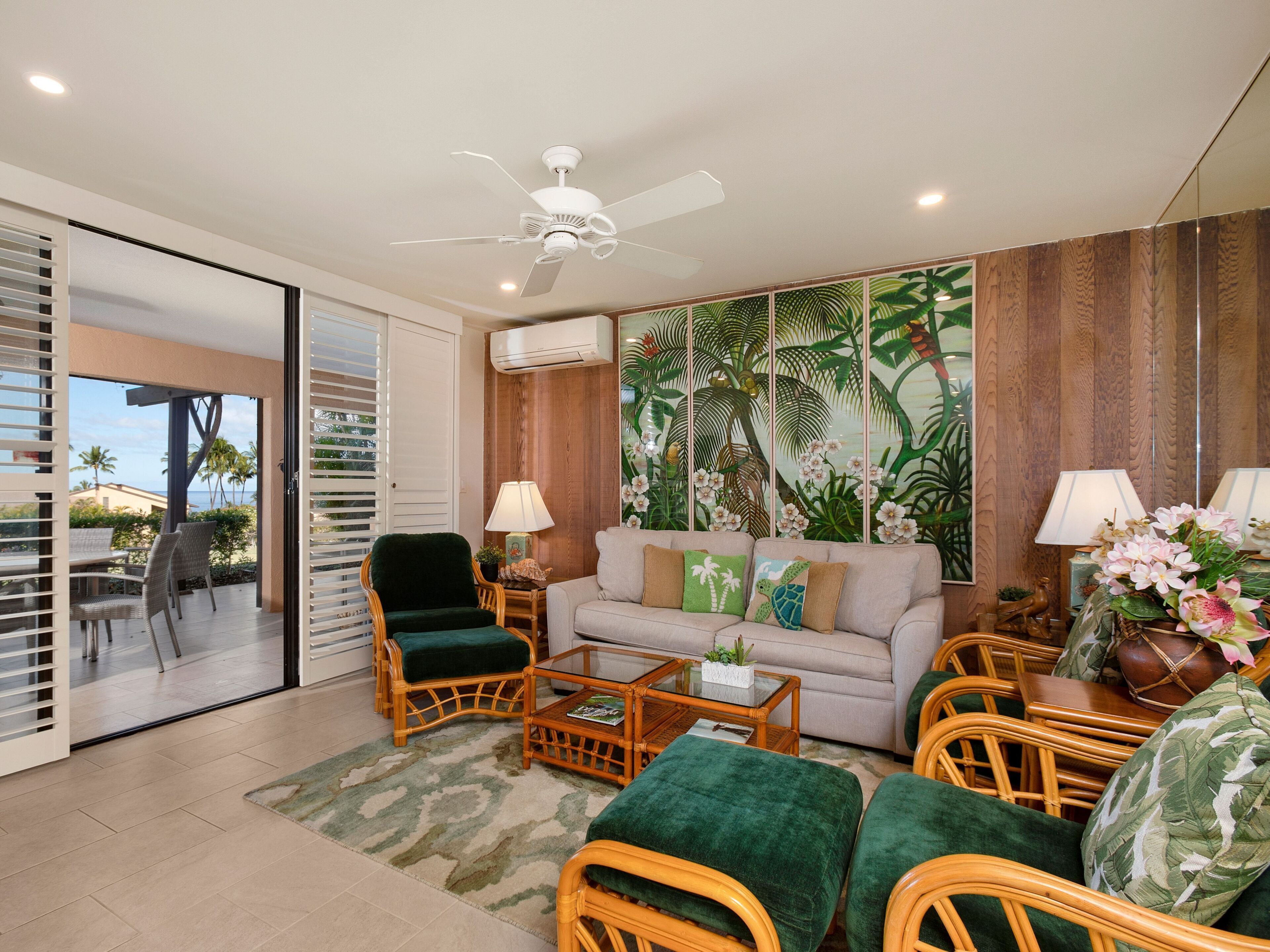 A living room with a sofa, chairs, a coffee table, and a ceiling fan.