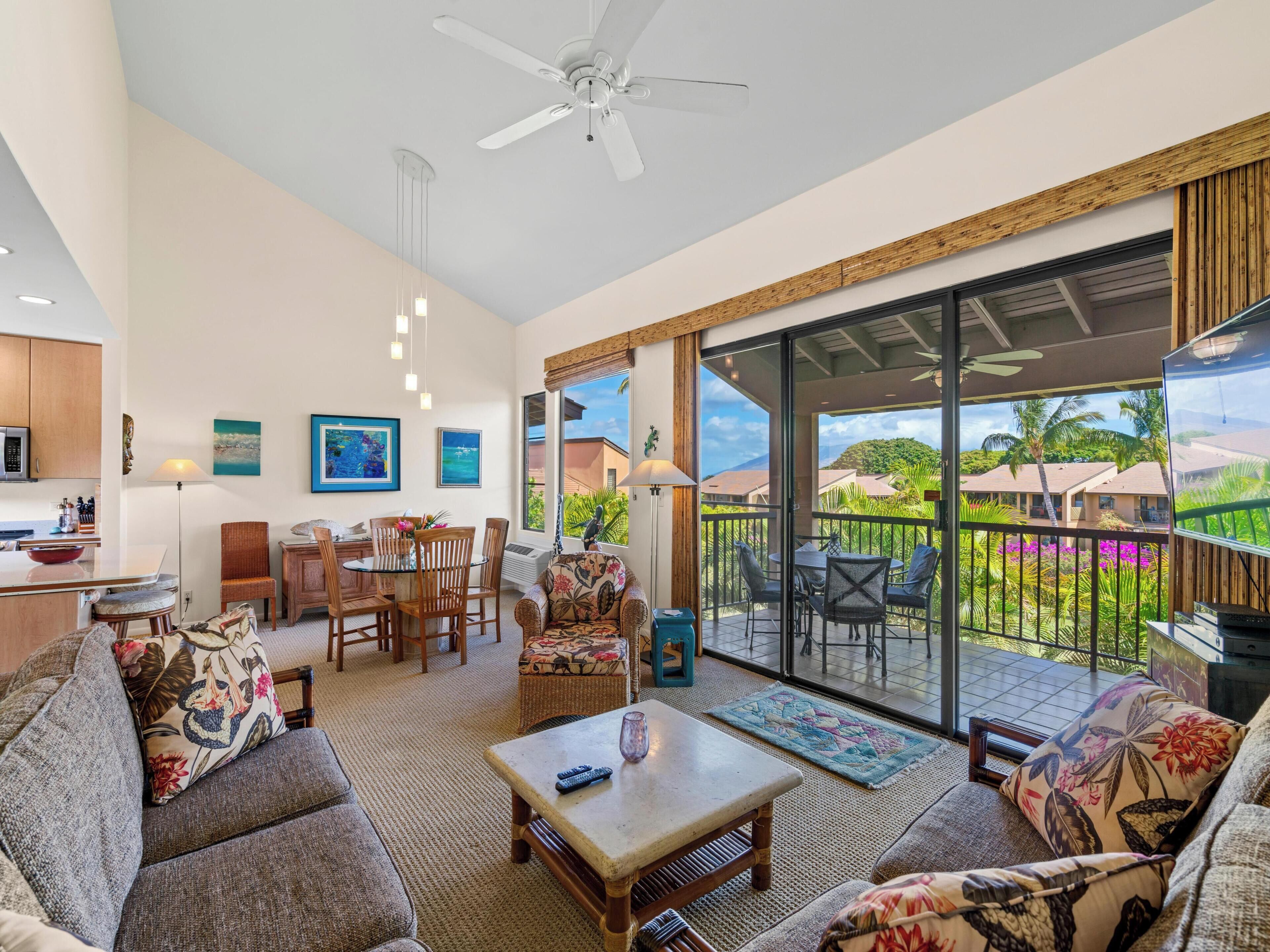 A spacious living area with a balcony, a dining set, and a kitchen area.