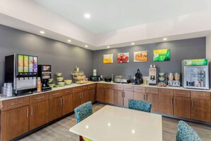 A modern kitchen area with a coffee machine, food display, and seating. - Quality Inn Cookeville (Cookeville)