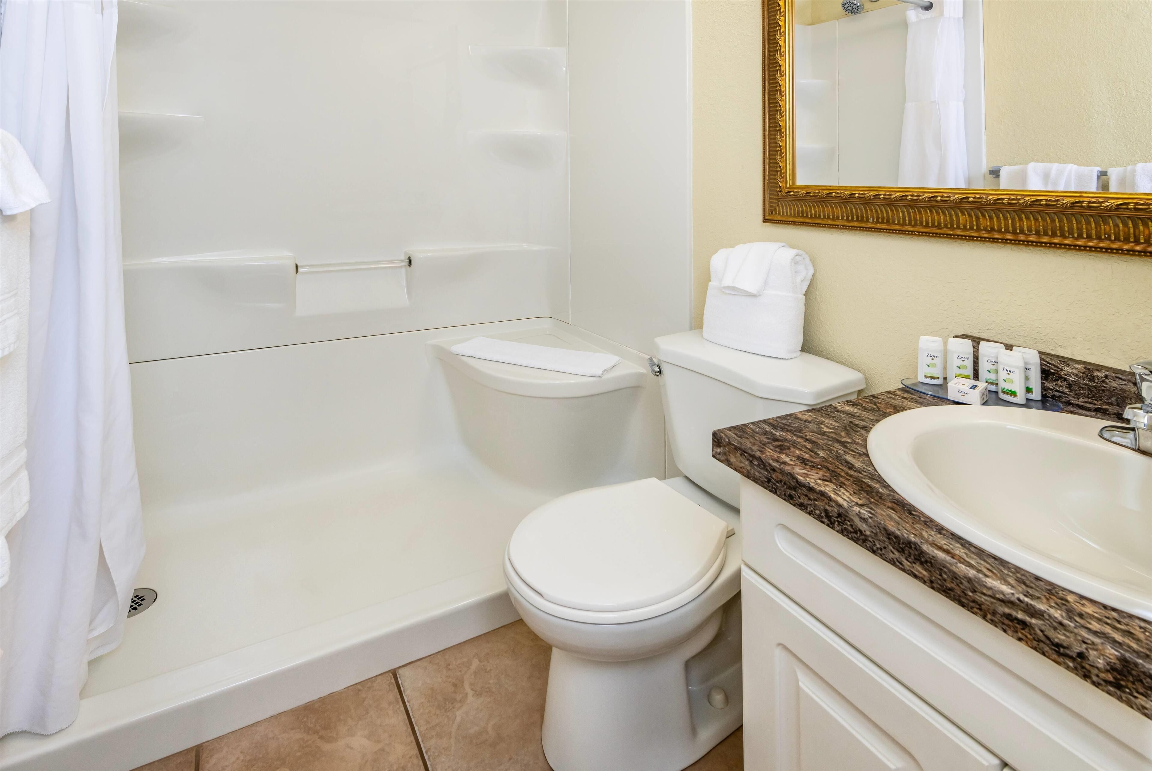 Un baño con bañera, inodoro y lavamanos.