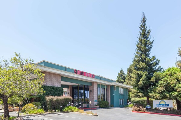 A building with a 'Sundowner' sign, a 'Days Inn' sign, and a parking lot. - Days Inn & Suites by Wyndham Sunnyvale (Sunnyvale)