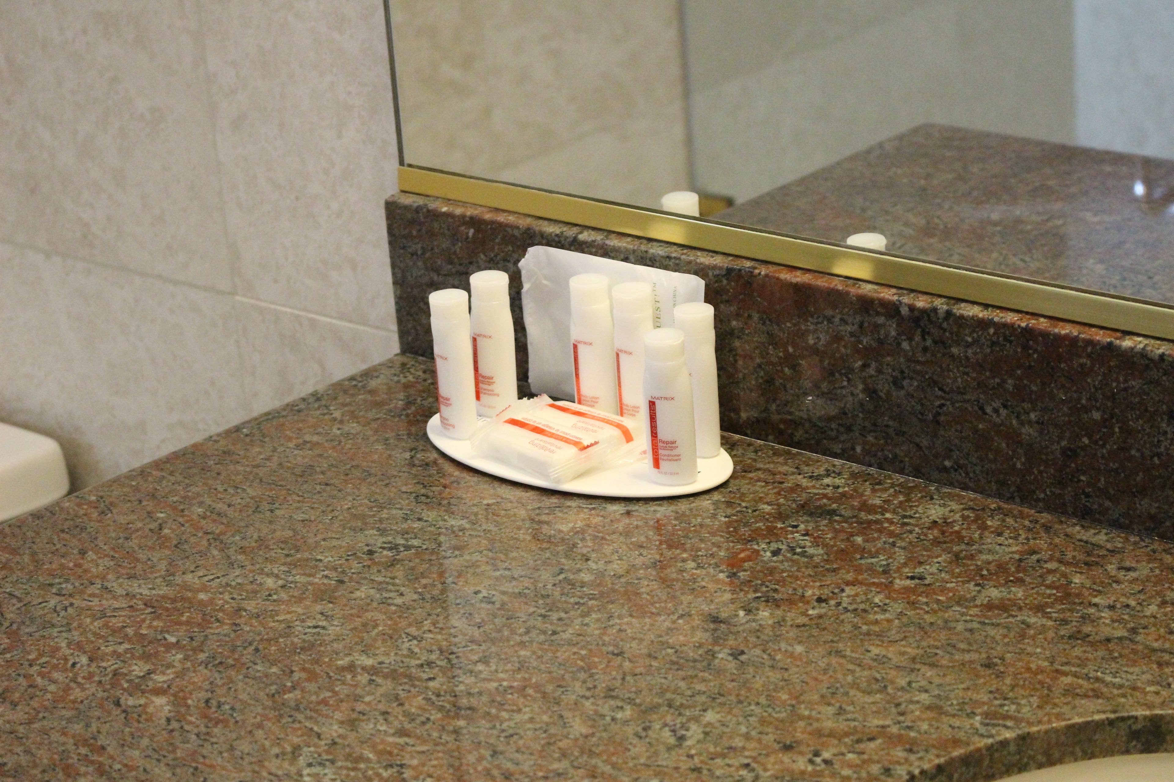A bathroom counter with a soap dispenser and a mirror.