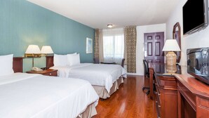 A hotel room with two beds, a desk, a television, and a door. - Days Inn & Suites by Wyndham Sunnyvale (Sunnyvale)