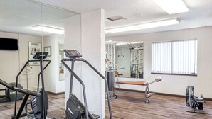 A gym with treadmills, a stationary bike, and a rowing machine. - Days Inn & Suites by Wyndham Sunnyvale (Sunnyvale)