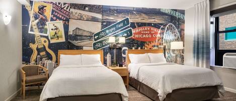 A hotel room with two beds, a cityscape mural on the wall, and a view of the city.