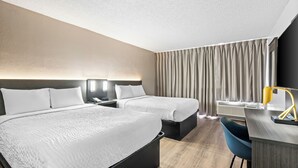 A hotel room with two beds, a desk with a chair, a nightstand, a lamp, and a large window with curtains. - Suburban Studios Pecos (Pecos)
