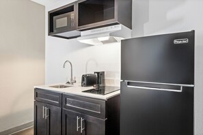 Escritorio, cortinas opacas, tabla de planchar con plancha