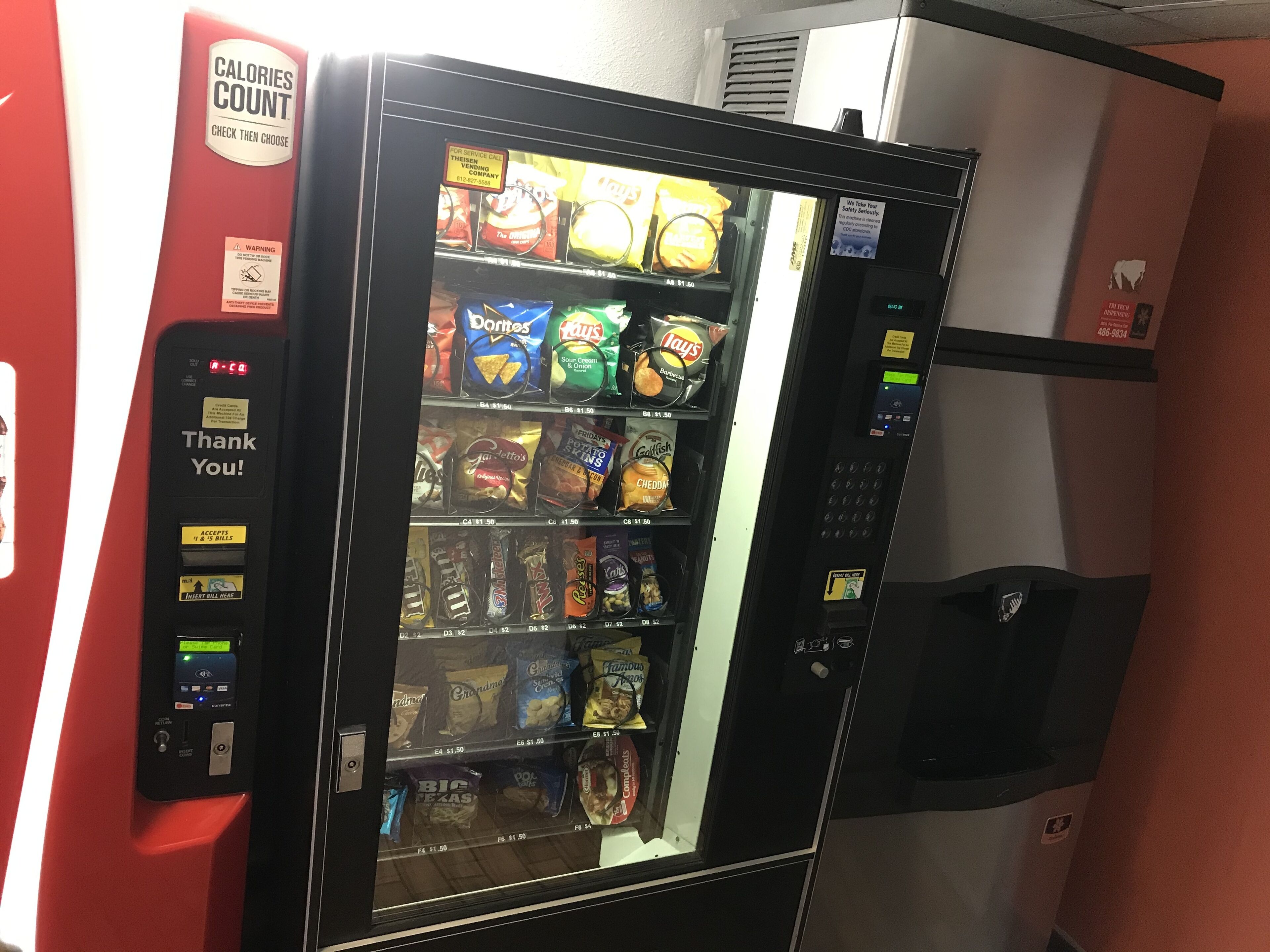 Un distributeur automatique de collations et de boissons, une pancarte indiquant « Merci ! » et une étiquette indiquant le nombre de calories.