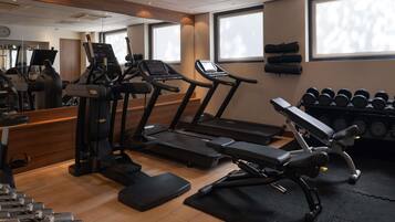 A gym with treadmills, dumbbells, and exercise equipment.