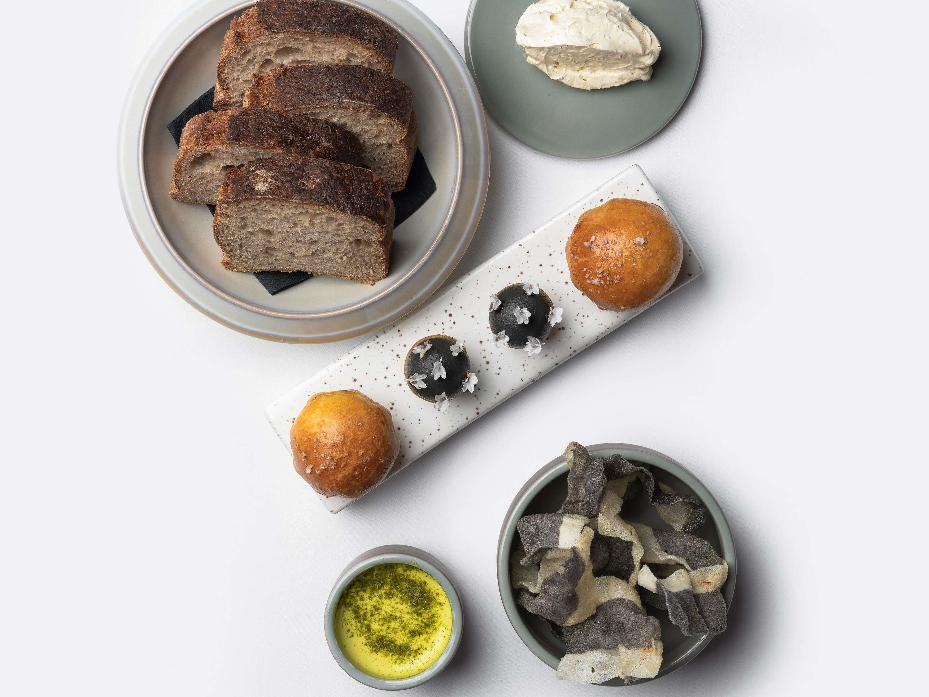 Ein Tisch mit Brot, Gebäck und zwei Schüsseln Essen.