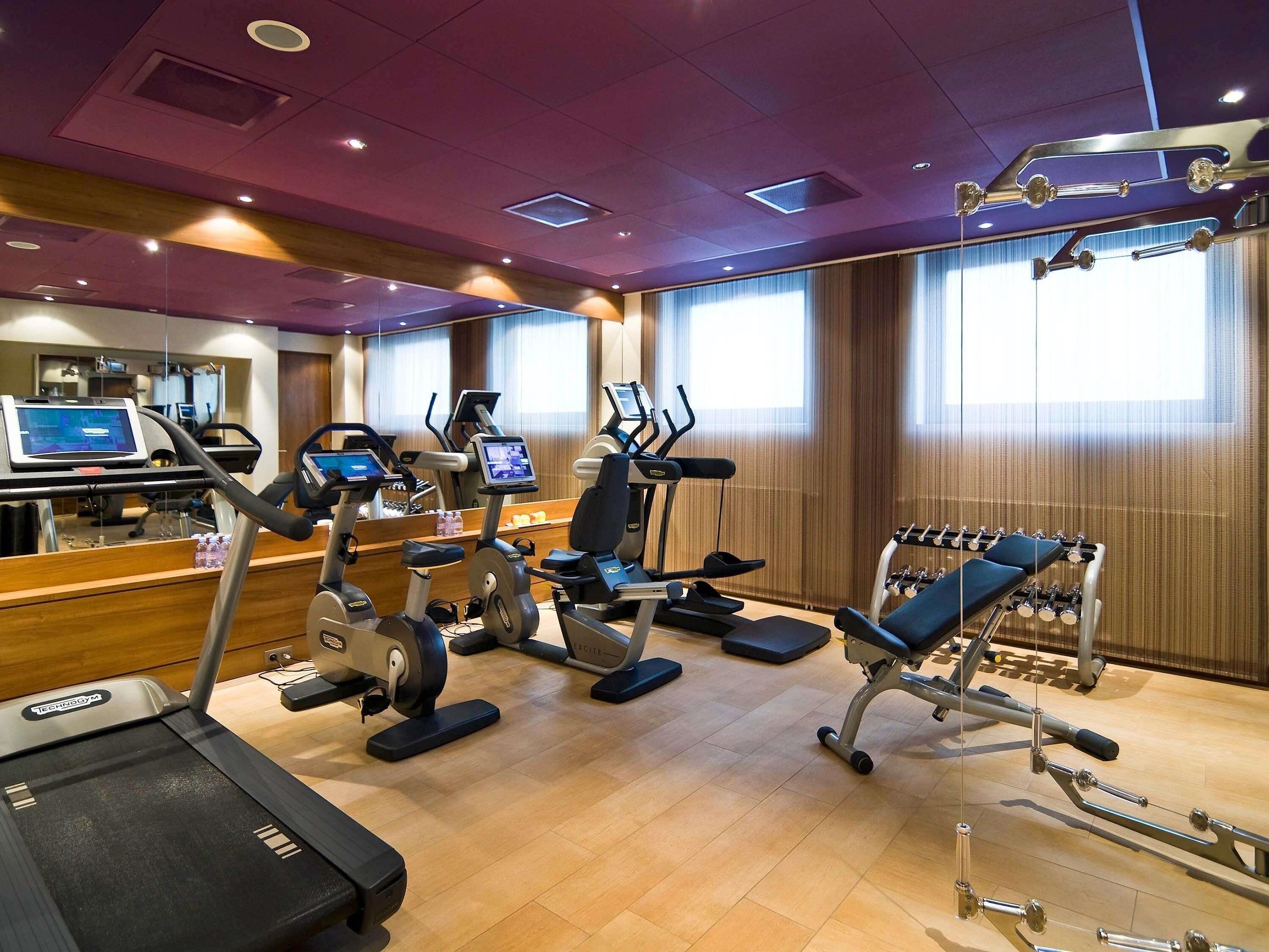 A gym with treadmills, elliptical machines, and weight equipment.