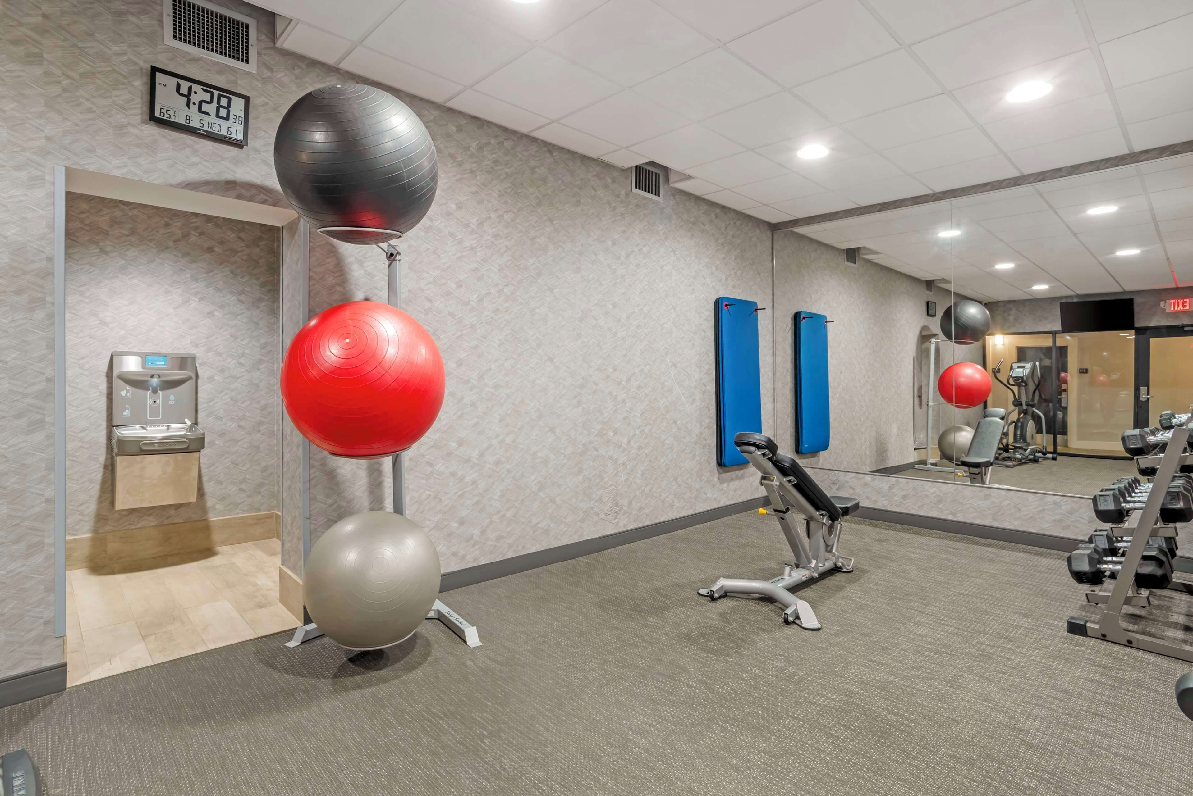 A gym with exercise equipment, a digital clock, and a water dispenser.