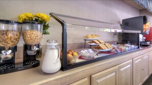 A buffet setup with various food items and a coffee station.
