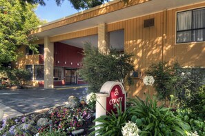A building with a red entrance, a sign reading "COUNTY IN", and a parking lot.