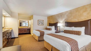Ein Hotelzimmer mit zwei Betten, einer Sitzecke, einer Küchenzeile und einem Badezimmer.