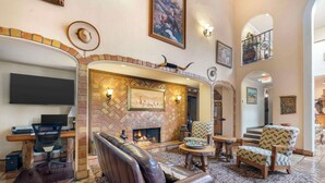 A spacious lobby with a fireplace, leather seating, and a flat-screen TV. - Best Western Casa Grande Inn (Pismo Beach)