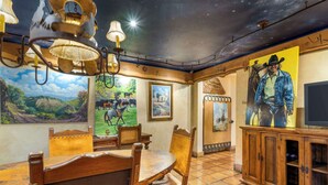 A dining area with wooden furniture, a ceiling mural, and artwork on the walls. - Best Western Casa Grande Inn (Pismo Beach)