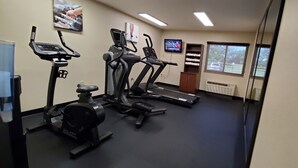 A gym with treadmills, an elliptical, and a stationary bike.