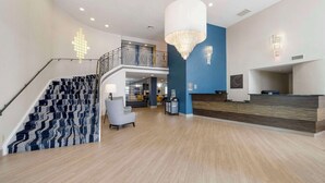 A spacious lobby with a staircase, a reception desk, and a chandelier. - Comfort Inn Edinburgh - Columbus (Edinburgh)